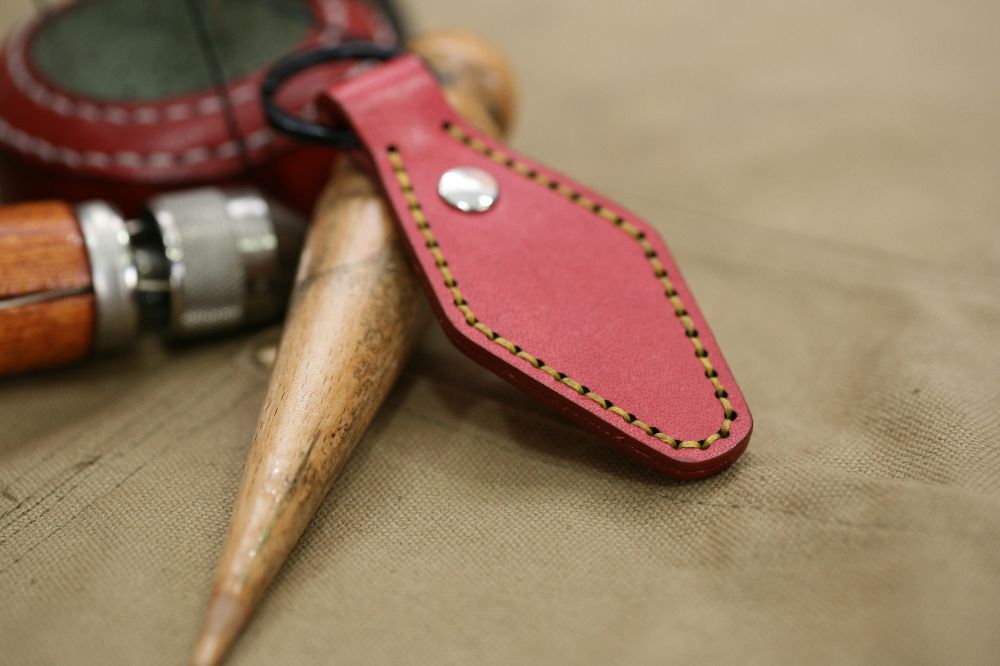 Handcrafted leather keyring with detailed stitching, available in brown and other colours