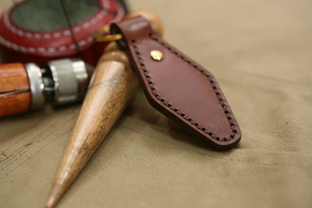 Handcrafted leather keyring with detailed stitching, available in brown and other colours