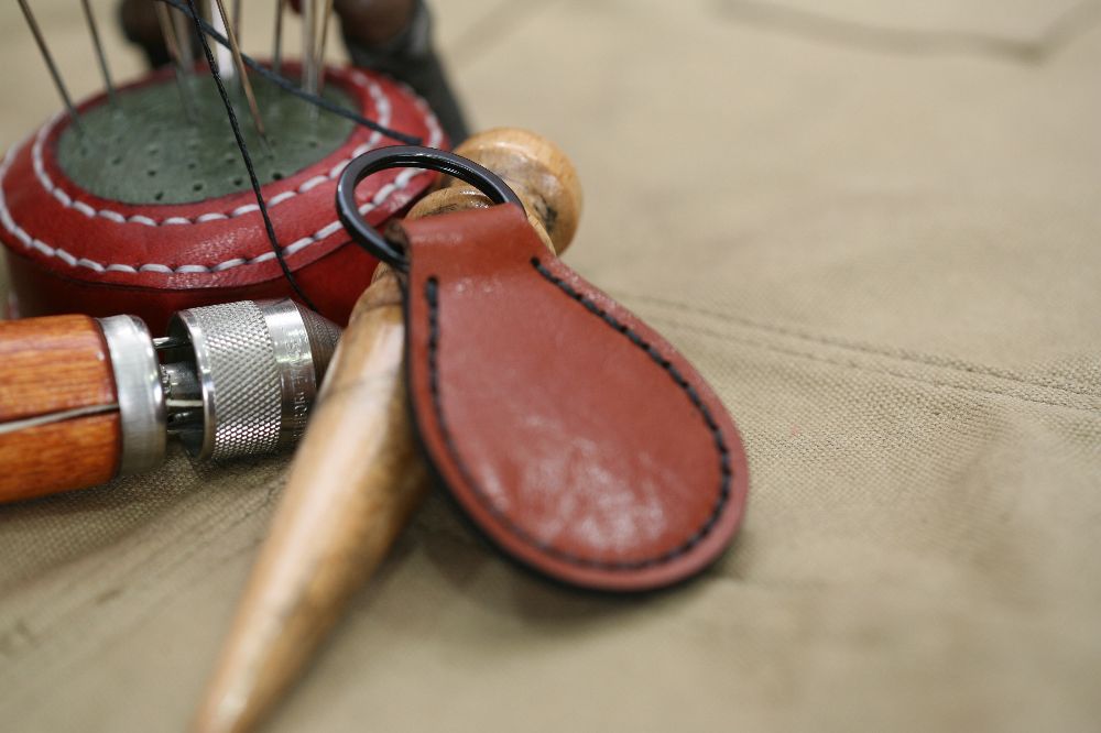 Handcrafted leather keyring with detailed stitching, available in brown and other colours