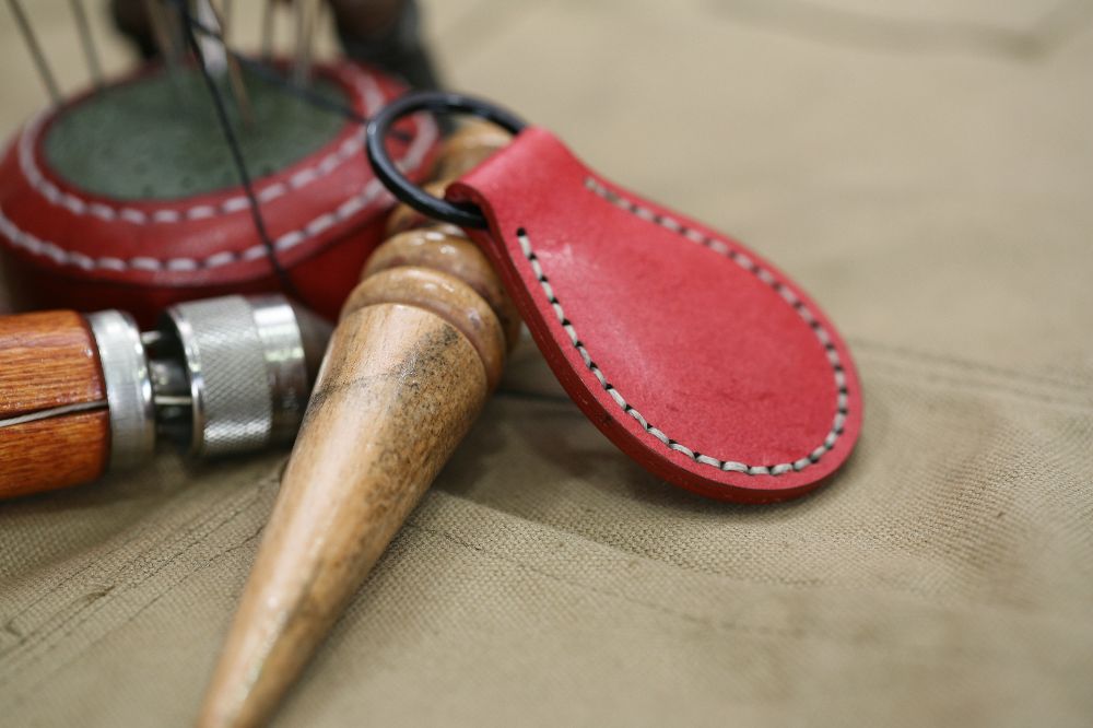 Handcrafted leather keyring with detailed stitching, available in brown and other colours