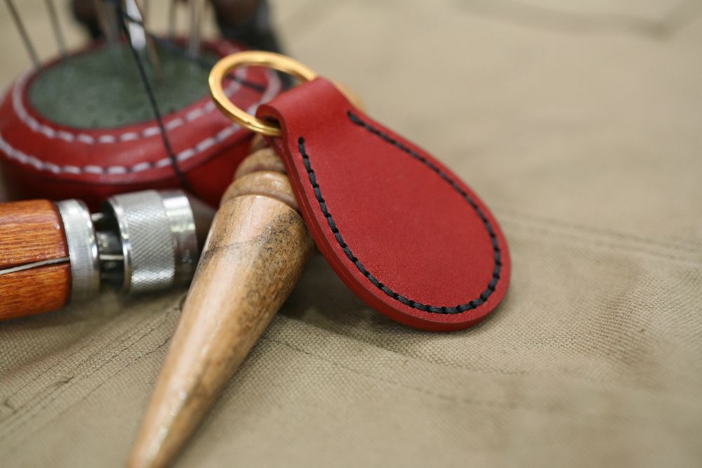 Handcrafted leather keyring with detailed stitching, available in brown and other colours